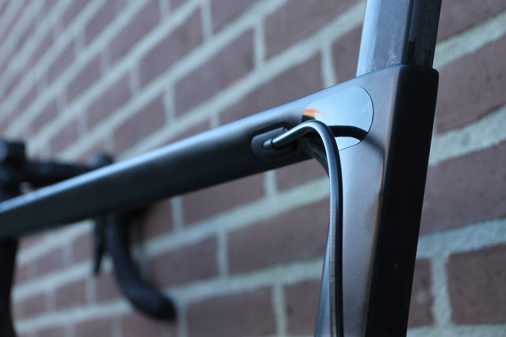 Transparent PPF protection film at the head tube of a black road bike, against rubbing cables