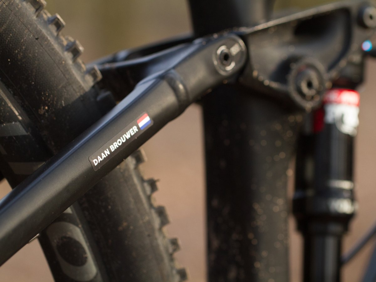Black name sticker with a Dutch flag on the rear triangle of a mountain bike