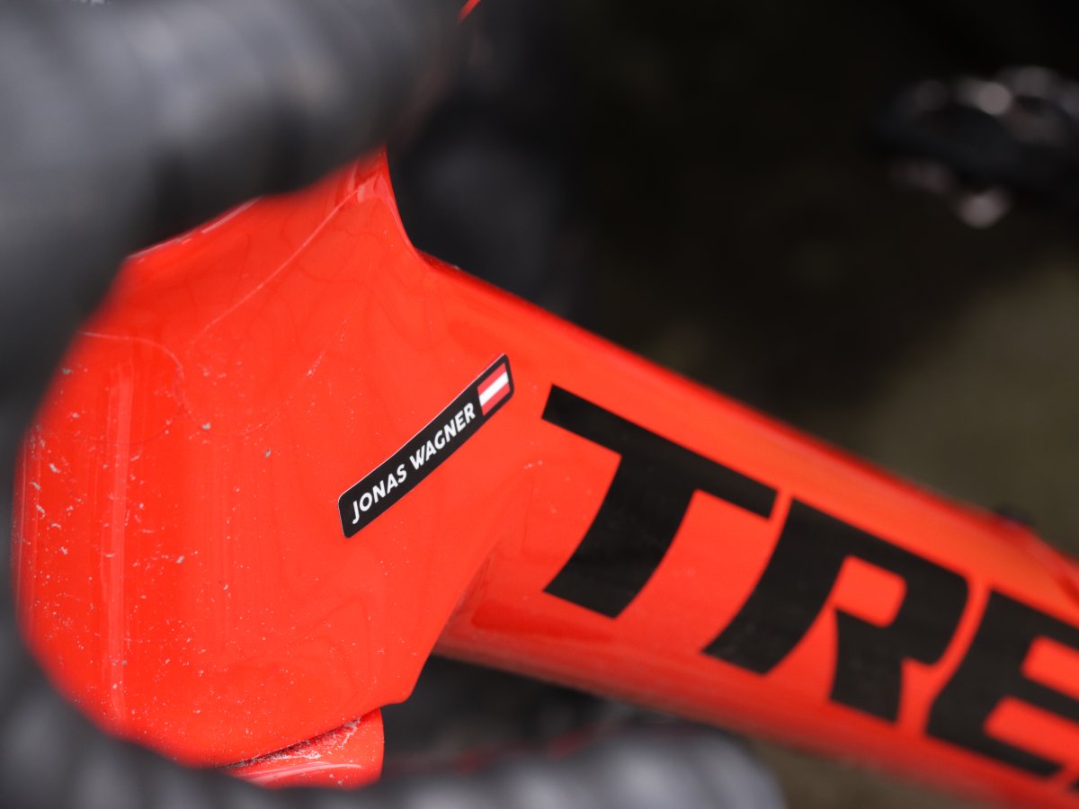Black name sticker with an Austrian flag on a red bike frame